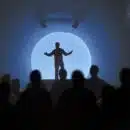 a silhouette of a man standing in front of a crowd